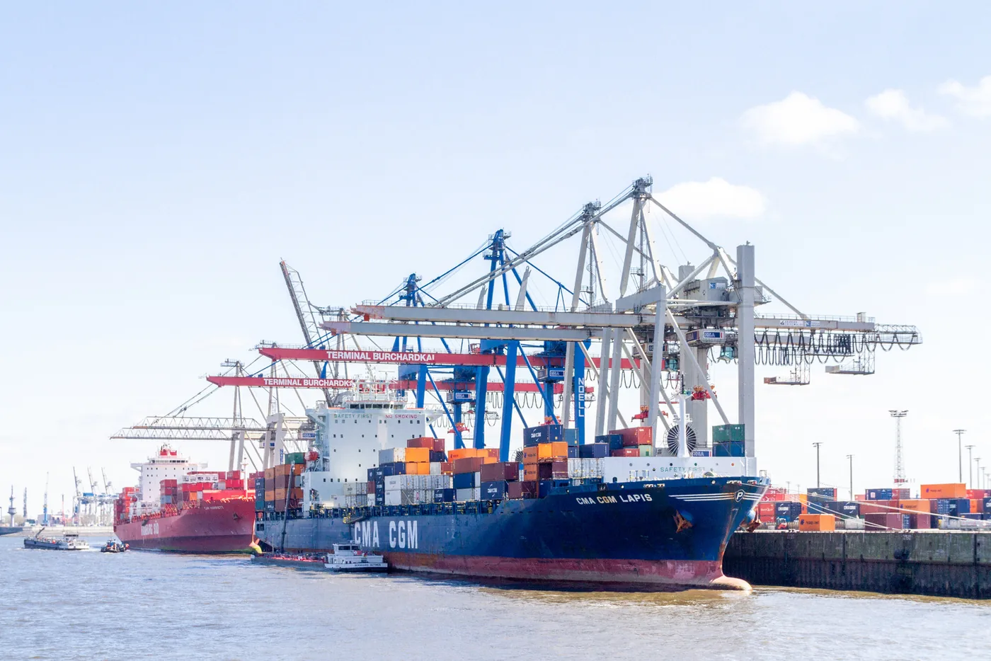 Container ship berthed under gantry cranes at a working port